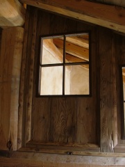Baita 2 interno: parete di separazione in legno vecchio con vetrate, clicca per ingrandire.